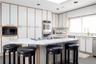 Kitchen with a kitchen bar, a sink, built in microwave, and double oven
