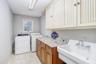 Oversized laundry room with built in custom cabinets, laundry tub, and washer and dryer included.