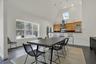 Dining space featuring a skylight, baseboards, high vaulted ceiling, and dark wood finished floors