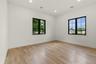 Light wood-finish flooring complements white walls with crisp baseboards