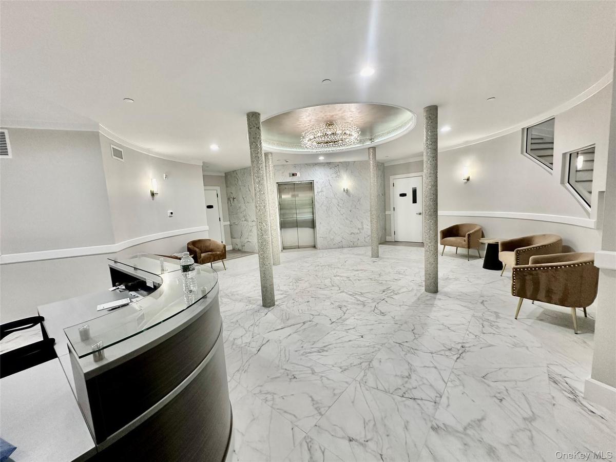A BEAUTIFULLY APPOINTED LOBBY WITH ELEVATOR AND ENTRANCE TO GARAGE