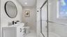 Shared Full bathroom featuring tile patterned floors, combined bath / shower with glass door, toilet, vanity, and baseboards