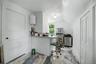 White walls with a window, stainless steel refrigerator, and stainless steel range
