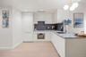 Kitchen with white cabinetry, light stone countertops, decorative backsplash, light wood-type flooring, and oven
