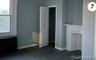 Unfurnished living room featuring baseboards, healthy amount of natural light, dark wood finished floors, and radiator heating unit