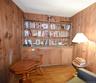 Wood paneling throughout this room, featuring a built-in shelving unit with lower cabinetry