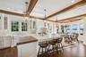 Kitchen featuring white cabinetry, pendant lighting, butcher block counters, plenty of natural light, and beam ceiling