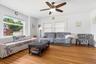 Sunlight pours through expansive windows, filling this spacious living room with warmth and natural beauty.