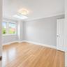 Primary Bedroom with a Large Walk in Closet, Skylight, Wood Flooring, and Crown Molding