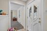 Foyer entrance featuring light carpet, plenty of natural light, a baseboard heating unit, and light tile patterned floors