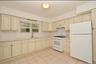 3rd Floor Kitchen with cream cabinetry, white appliances, light tile patterned floors, and under cabinet range hood