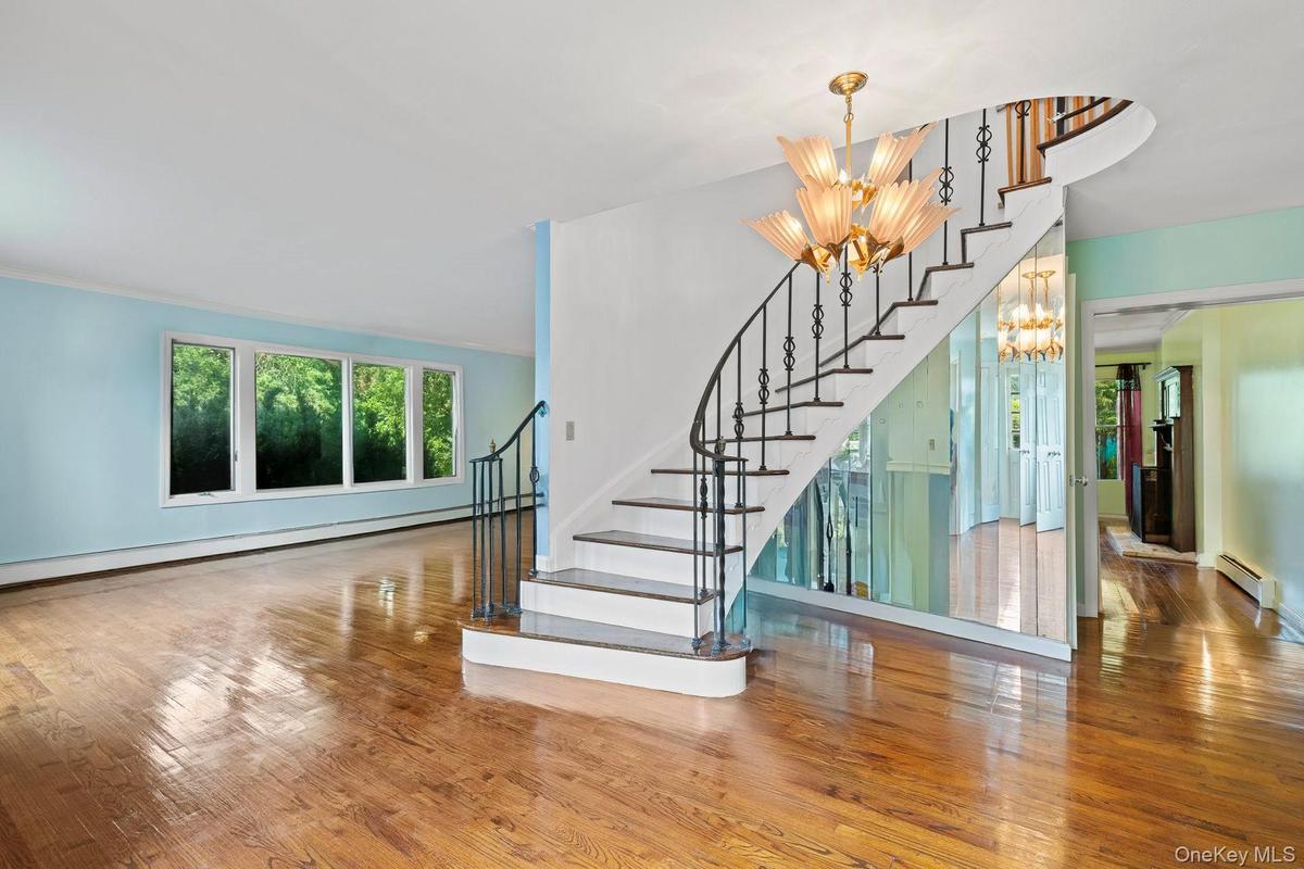 Staircase featuring hardwood / wood-style floors, a chandelier, a baseboard radiator, and a baseboard heating unit