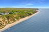 Aerial view of waterfront with a beach and a forest