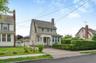 Two-story residence featuring light-colored siding and a covered porch