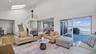 Living area with high vaulted ceiling, a skylight, stairs, and a water view