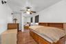 Bedroom with wood finished floors, ceiling fan, and a closet