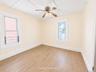 2nd fl room featuring wood-finish flooring and two windows with white trim