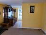 Hallway featuring baseboards, light colored carpet, and light tile patterned floors