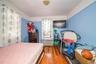 Bedroom with wood-type flooring and radiator heating unit