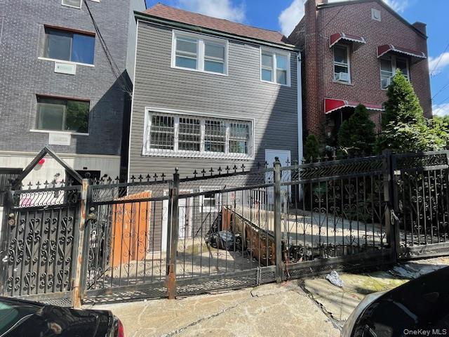View of front of property with a fenced front yard and a gate