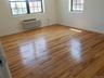 Unfurnished room with light wood finished floors and a wall unit AC