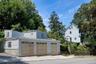 View from the side street. 3 car garage, with two rooms above it. Can be an office or additional storage space.