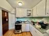 3 - Kitchen with white cabinetry, stainless steel gas range oven, a sink, and light wood-type flooring