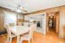 Hardwood flooring defines this dining space, featuring a ceiling fan with integrated lighting