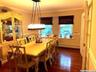 Dining area with a baseboard heating unit, dark wood-type flooring, and ornamental molding