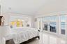 Bedroom featuring french doors, access to exterior, vaulted ceiling, and a water view