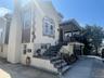 View of front facade featuring stairway and stucco siding