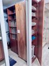 Built in clothes hamper adjacent to primary walk in closet