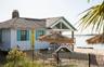 View of front of home featuring a fenced front yard, stairs, board and batten siding, a chimney, and a water view
