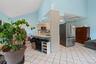 Kitchen featuring freestanding refrigerator, light countertops, light tile patterned floors, black microwave, and open floor plan