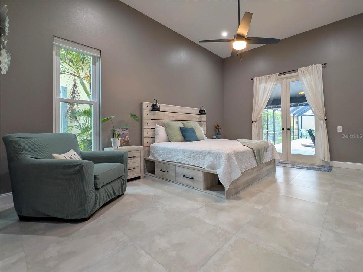 Primary Bedroom w/ french doors leading out to pool.