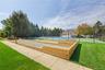 Bocce ball court with wood-finish perimeter, hardscaped pathway, and manicured lawn