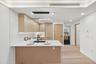 Kitchen featuring light brown cabinets, a peninsula, a sink, light wood-type flooring, and light countertops