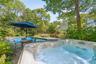 View of pool featuring a hot tub, a fenced in pool, and fence