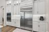 Built-in oversized refrigerator accompanies the stunning floor to ceailing cabinetry.