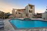 Back of property featuring outdoor lounge area, a pool with connected hot tub, a patio area, stairway, and a wooden deck