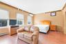 Bedroom featuring crown molding, light wood finished floors, and a wall mounted AC