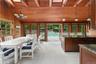 Dining area featuring french doors, a skylight, wooden walls, high vaulted ceiling, and a wood ceiling with exposed beams