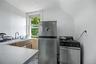 White walls with a window, stainless steel refrigerator, and stainless steel range