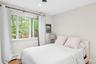 Bedroom with wood finished floors, baseboard heating, and recessed lighting