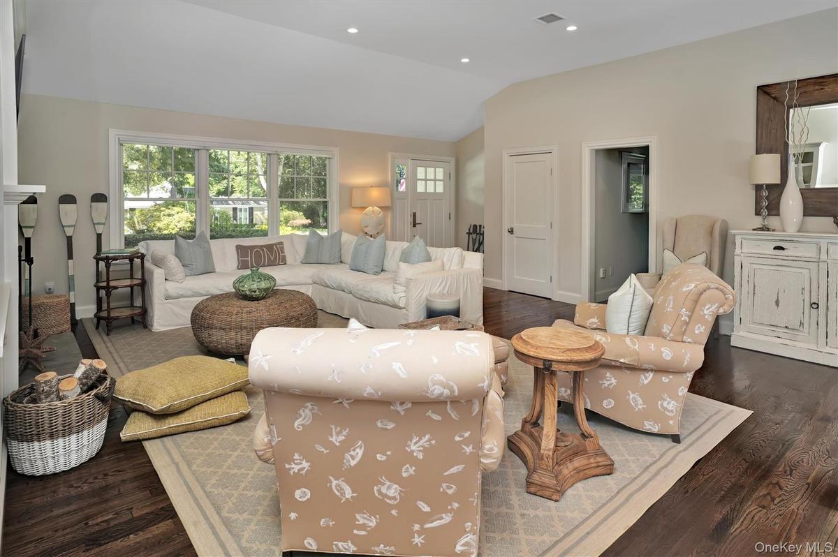 Living room with dark wood finished floors, vaulted ceiling, and recessed lighting