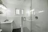 Glass-enclosed shower with white subway tile surround and brushed nickel fixtures