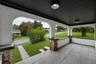 Inviting covered porch with a textured stucco finish and stone-clad pillars