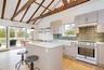 Kitchen with high vaulted ceiling, high end white range, a breakfast bar area, tasteful backsplash, and a kitchen island