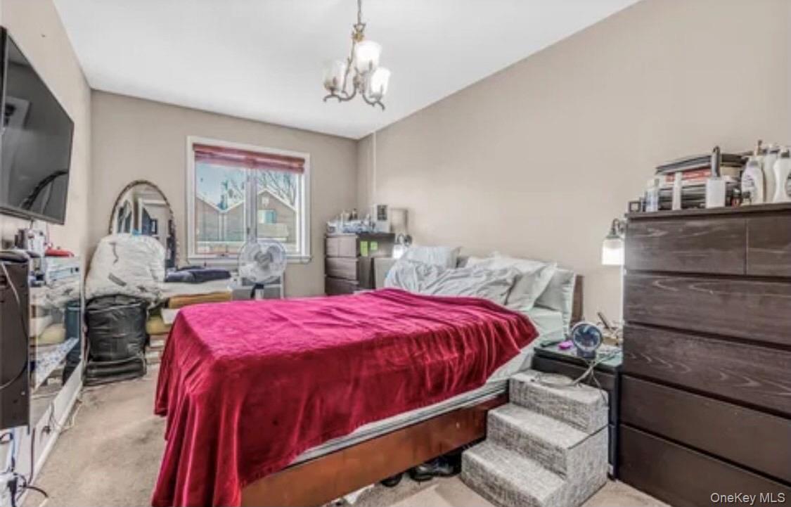 Bedroom featuring carpet flooring and a chandelier