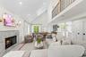 Living area featuring a premium fireplace, high vaulted ceiling, wood finished floors, and recessed lighting